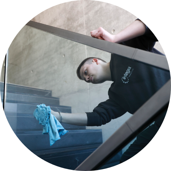 Junger Mann reinigt Treppengeländer mit Lappen